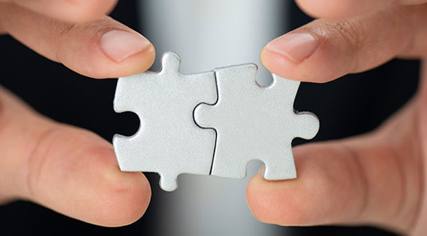 Person holding puzzle pieces in hand