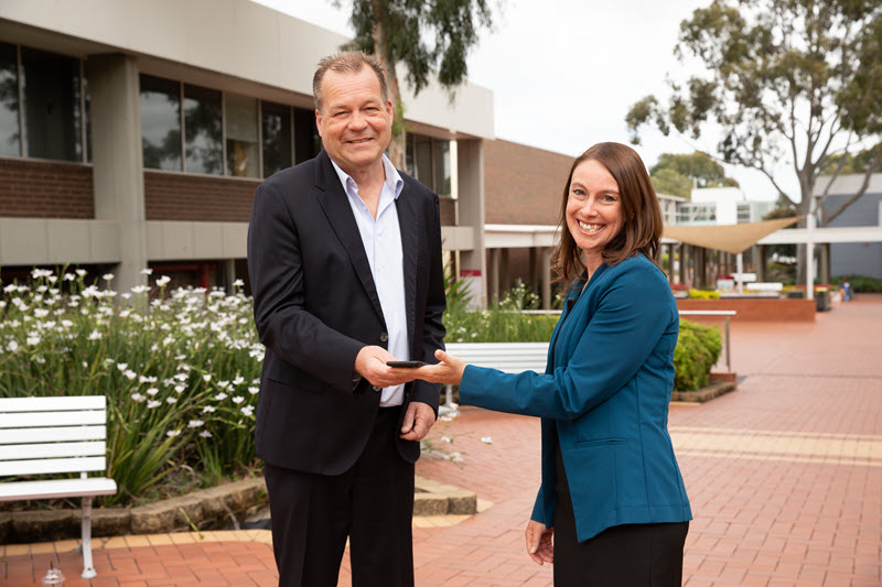 Pictured: Mike Lanzing and Dr Michelle Cull shaking hands and smiling in a university quad.