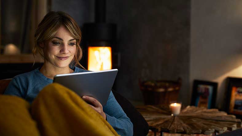 Woman sitting and smiling at ipad