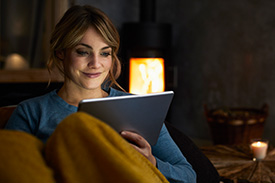 Woman sitting and smiling at ipad