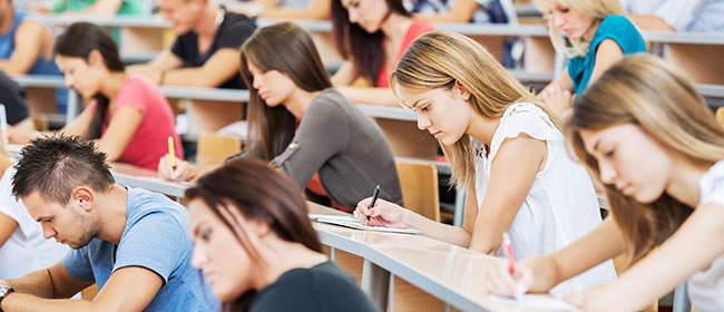 Students sitting in a lecture hall, federal budget impacts on higher education.