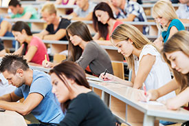 Students sitting in a lecture hall, federal budget impacts on higher education.