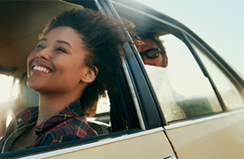 Lady smiling out the window of a car