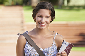 Smiling female university student walking to class