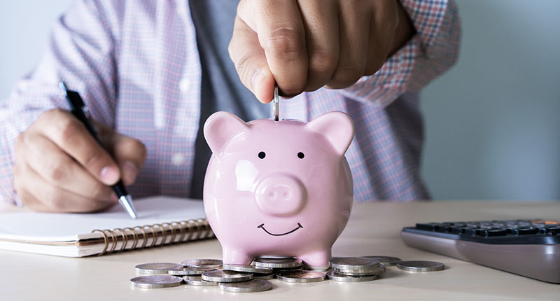 Financial health check - image of person putting money into a piggybank