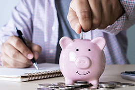 Financial health check - image of person putting money into a piggybank