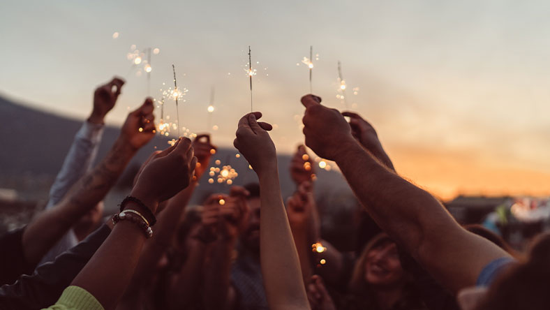 A group of people holding up sparklers. 