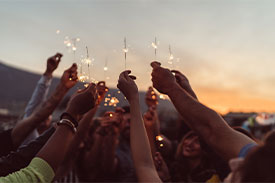 A group of people holding up sparklers. 