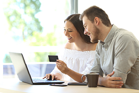 Family researching on a laptop while holding a credit card