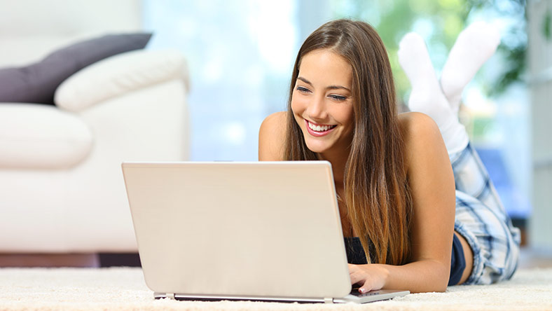 Woman at home shopping online with her laptop.  