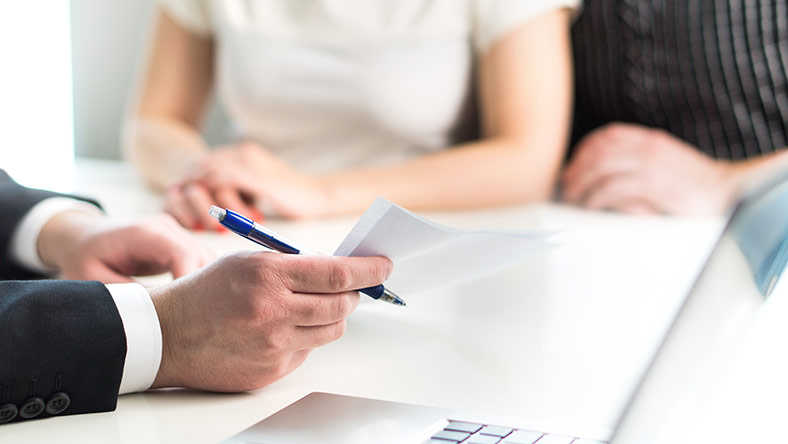 A young defacto couple working with a tax agent to complete their tax return