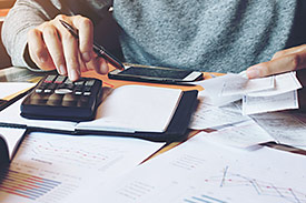 Using a calculator to work out 2018-2019 tax deductions.