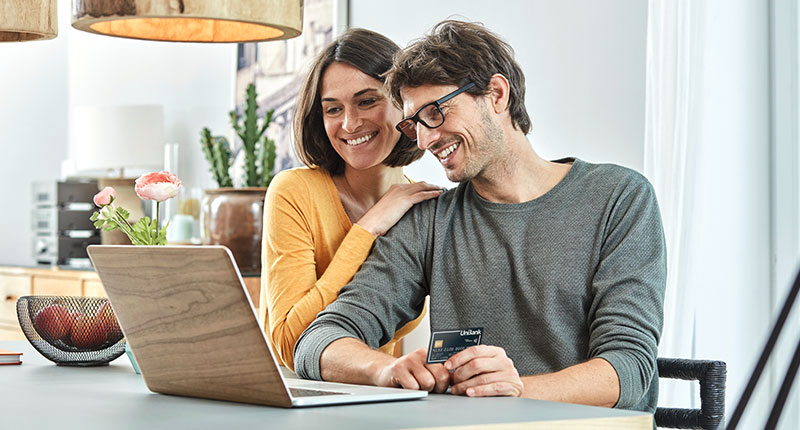 Your credit report - image of smiling couple sitting together in front of a laptop in a stylish apartment