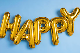 Five gold balloons spell out the word happy.