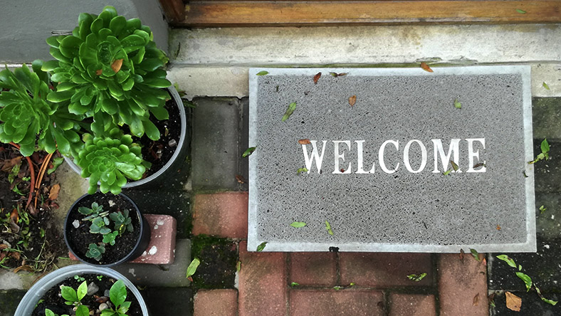 A doormat to a home owner's property reading 'Welcome'.