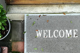 A doormat to a home owner's property reading 'Welcome'.