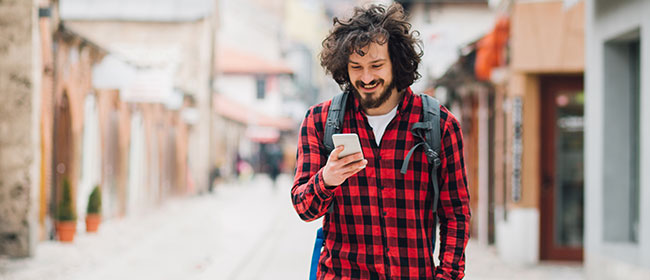 A young man using his mobile phone while travelling overseas.