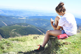 Student traveller resting on hike overlooking mountains