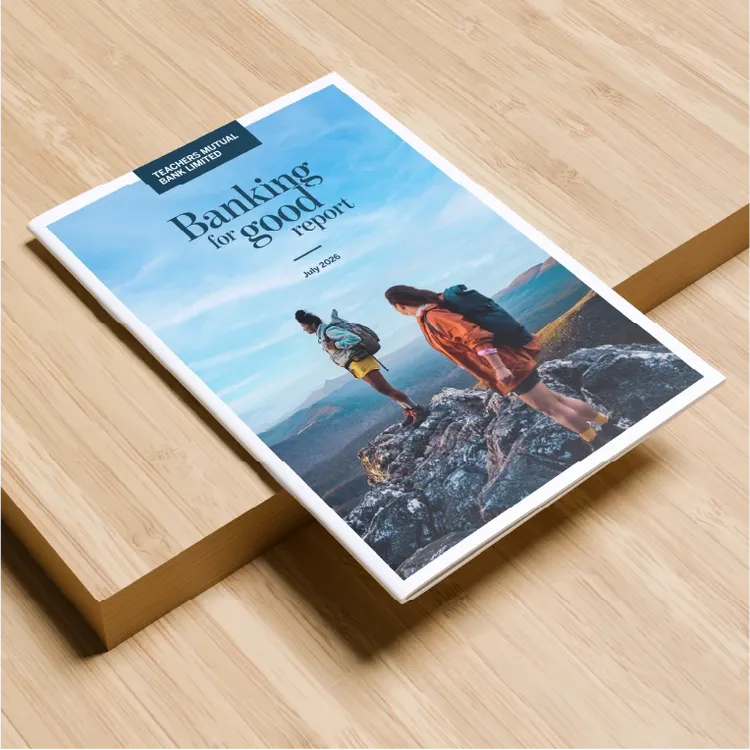 A printed report titled 'Banking for good report' is placed on a light wooden surface.